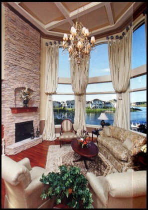The great room’s 18-foot high bay windows fill the space with lake views.
