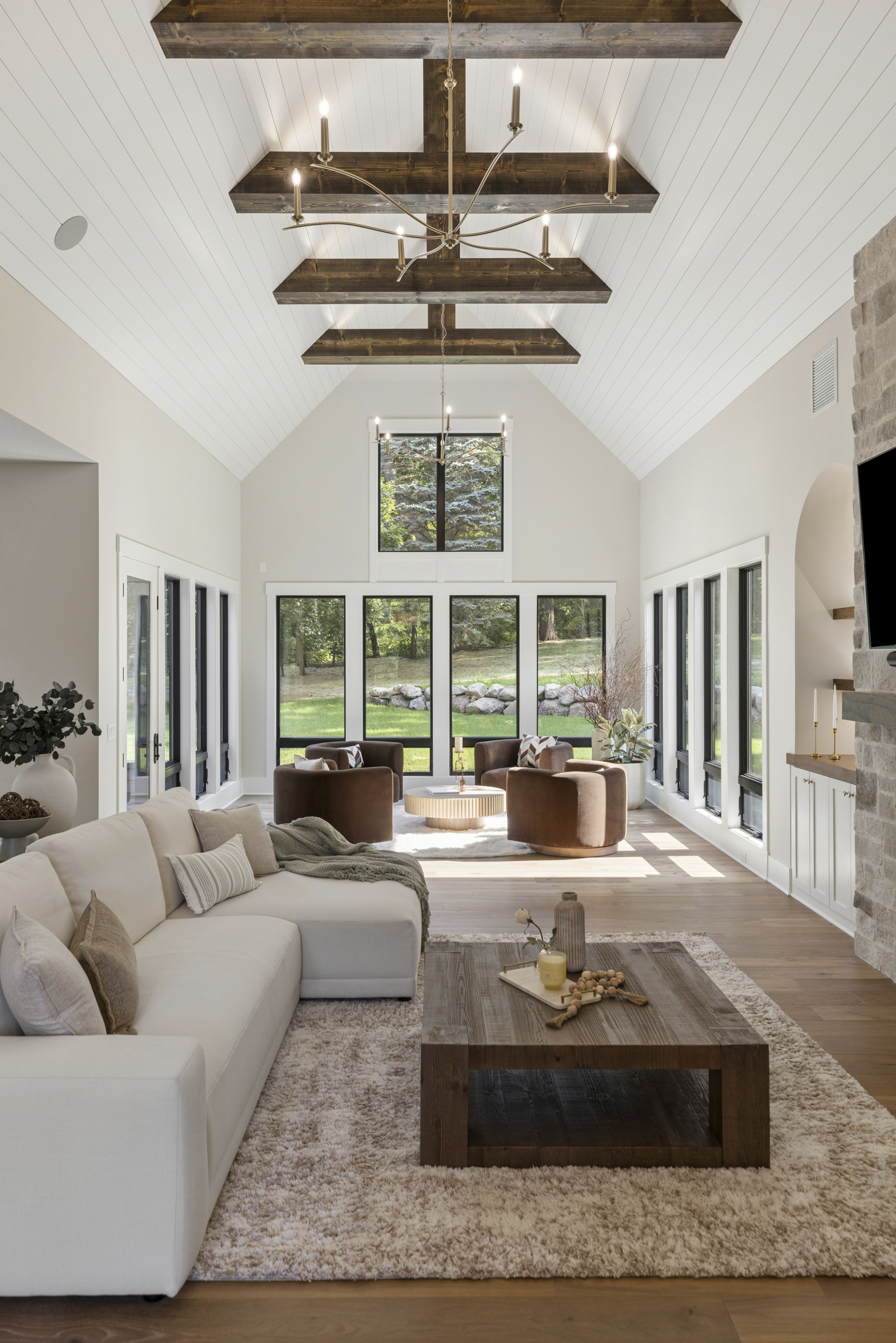 Great room at 6205 Hillside with soaring vaulted ceiling, exposed wood beams, large windows, hardwood floors, and abundant natural light.